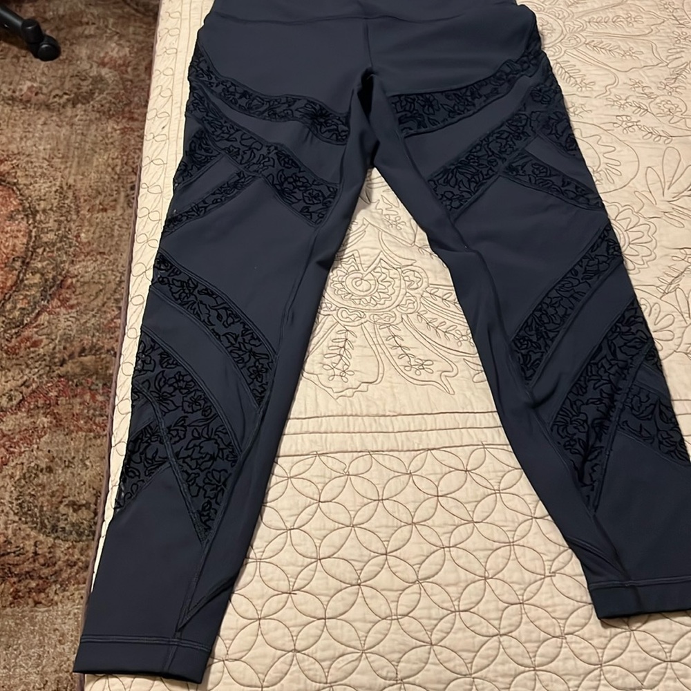 NWOT LULULEMON LEGGINGS BLACK WITH LACE LOOKING TRIM DOWN LEGS. SIZE 12